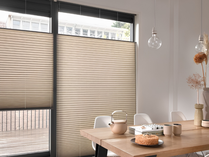 Beige Luxaflex plisségordijnen in hoge eetkamer met top down bottom up systeem