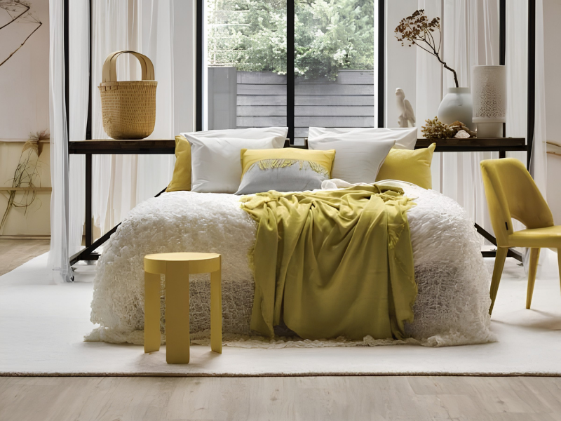 Licht vloerkleed onder bed in slaapkamer met gele accenten