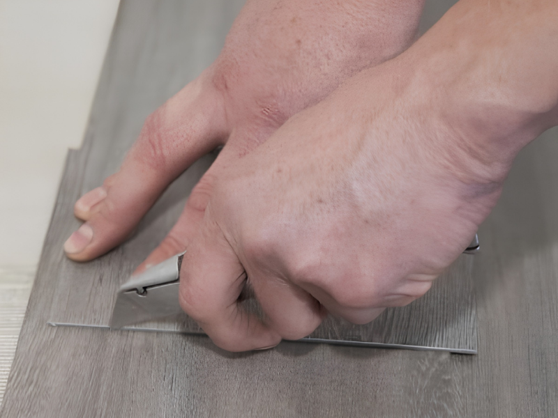 Detail van PVC vloer leggen met mes bij vloerverwarming
