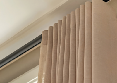 Close-up van beige gordijnen aan zwarte gordijnrail
