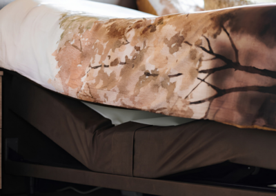 Detail van warm bedtextiel met natuurprint in slaapkamer Berkenwoude